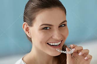 Dental care. Smiling woman using removable clear teeth braces