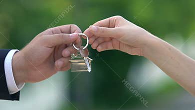 Female hand taking house key from real estate agent, apartment rent, property