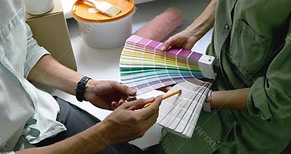 Couple discussing and choosing paint color from swatch for new home