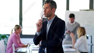 Handsome businessman looking to sideways while thinking on coworking place. Finally, he`s looking at camera