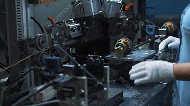 Close up engineer processing electrical motor on automatical machine at factory
