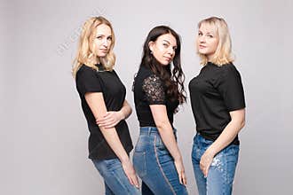Group of smiling young friend woman hugging posing looking at camera at white studio background