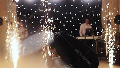 Young beautiful bride and groom dancing first dance at the wedding party shrouded by confetti. Feel happy