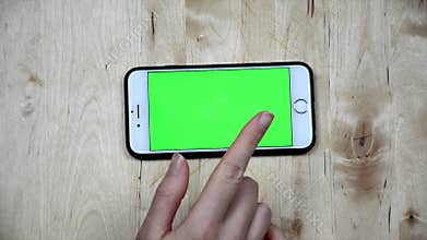 Swipe smartphone screen. Top view touching mobile phone with fingers, green screen, alpha channel phone screen