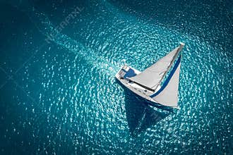 Regatta sailing ship yachts with white sails at opened sea. Aerial view of sailboat in windy condition