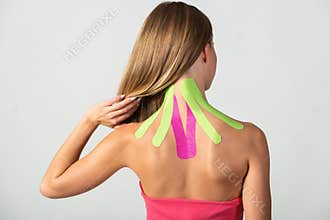 Kinesio tapes on the young woman`s back