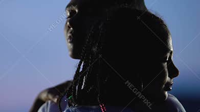 Loving Afro-American couple tenderly hugging against evening sky, emotions