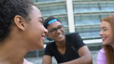 Mixed-race female chatting and laughing with friends, communication and trust