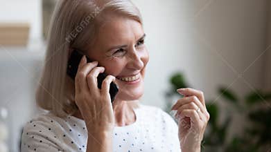 Happy beautiful mature woman making phone call close up