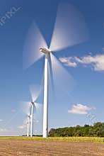 Green Energy Wind Turbines In Field of Sunflowers