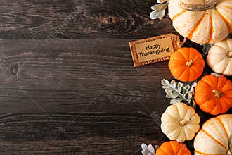 Happy Thanksgiving tag with fall side border of pumpkins and leaves on a dark wood background