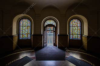 Looking outside via arched door and colorful arched window