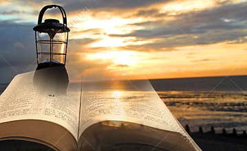 Bible lantern lamp light lamplight divine spiritual book open sky beach sea ocean