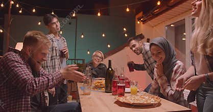 Closeup portrait of diverse multiracial group of friends being delivered pizza celebrating happily at fun party in cozy