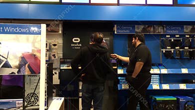 Motion of people playing VR game and worker explains how to operate the game inside the store