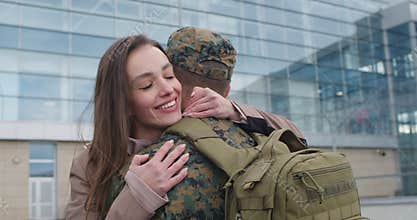Girl running to and hugging her military husband