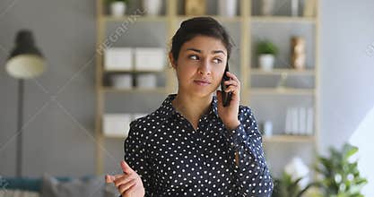 Young indian woman make phone call standing at home office