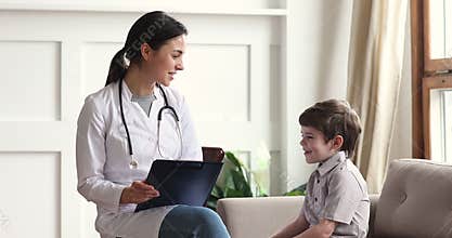 Friendly woman pediatrician and child boy talk at pediatric checkup