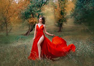 Glamorous brunette woman in red scarlett dress very high sexy slit on her leg.