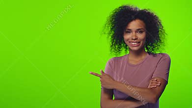 African American female points with forefinger away, indicates on a blank wall