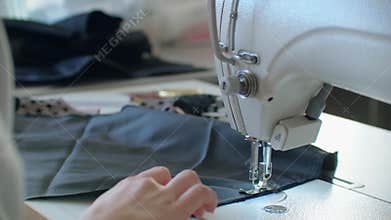 Sewing Machine Needle in Motion. Close-up of sewing machine needle rapidly moves up and down. The tailor sews black