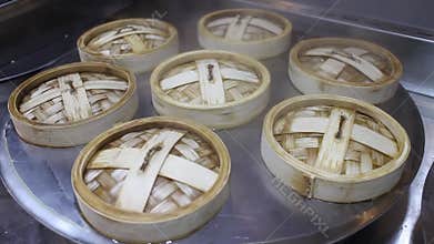 Dim-sum or dumplings steam in the kitchen of Chinese restaurant close up.
