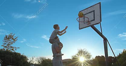 Father with son enjoy a day at the park and playing basketball.