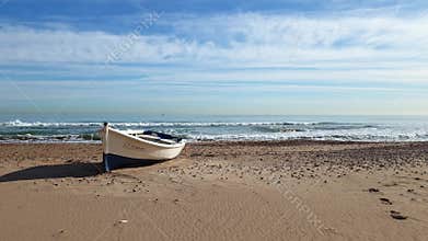 Lonely wooden boat on a sandy beach