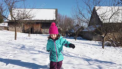 Slow motion of a kid in winter clothes running in the snow