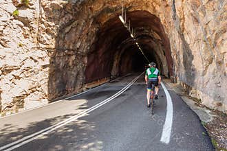 Cyclist riding through a tunnel in the rocks