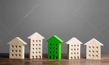 Green figure of a residential building stands out among the rest of the houses. eco-friendly and energy saving