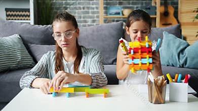 Slow motion of pretty woman playing blocks with cheerful daughter having fun