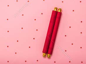 Rolled red flower on pink background with sequins.