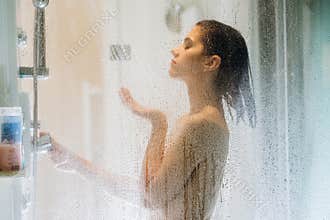 Morning shower.Taking rejuvenating cold shower.Self care moment.Everyday personal hygiene.Unfocused woman showering in glass