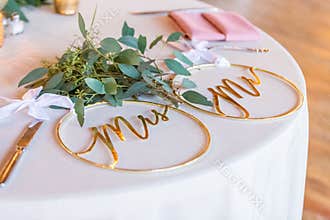 Closeup shot of round ring-shaped golden wedding decorations with writings \"Mr\" and \"Mrs