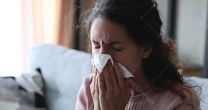 Ill young woman suffering from allergy, sniffles, stuffy nose problem