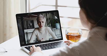 Two young business women distance workers talk in videoconference chat