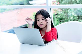 A 6 year old Asian girl wearing red shirt Watching a documentary From notebook