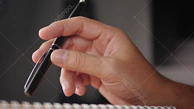 Businessman waiting for something and hand tapping with pen on the table
