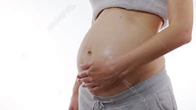 Close up of pregnant woman apply skincare cream on pregnant belly. 6k.