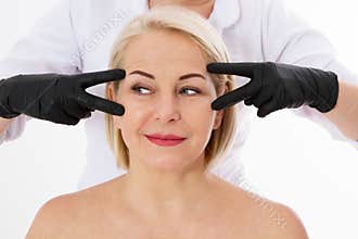 Wrinkles aging and botox injection concept - middle age beautiful woman and hands of plastic surgeon isolated on white background
