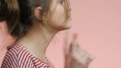Young woman head dancing with a negative pregnancy test on pink studio background, girl is happy,sense of freedom from commitment