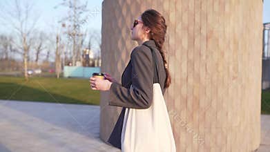 A beautiful Caucasian woman walks in park with a cotton eco bag of beige color at sunset. Reusable materials, life