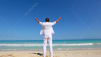 Young man on beach hold hands arms up Vacation concept of freedom travel