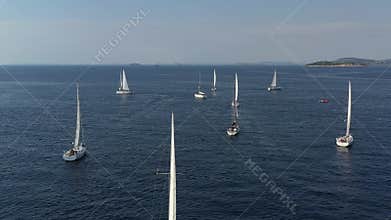 Ranks from yachts of participants of a regatta goes on a start point, is a sailing race at Croatia, reflection of sails