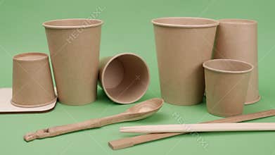 Environmental paper and wooden utensils on a green background.