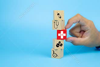 Close-up hand choose a cube wooden toy blocks with a red cross heart rhythm icon stacked