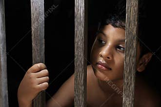 Sad little boy look from window. Portrait of a sad innocent child looking out the window.
