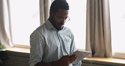 Focused young biracial businessman using electronic gadget.