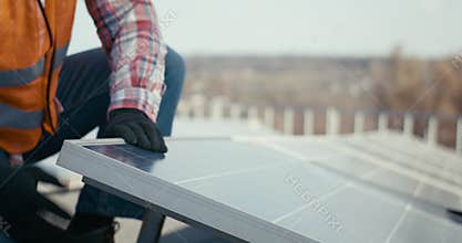 Technicians installing solar panels on metal stand